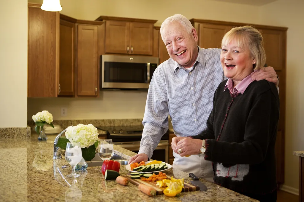 Senior couple cutting vegetables in a kitchen